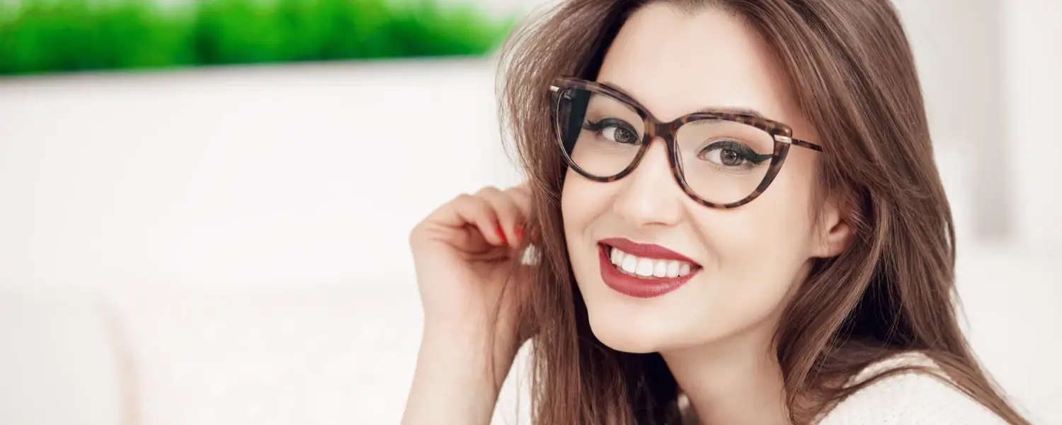 Young woman smiling with black frame eye glasses.