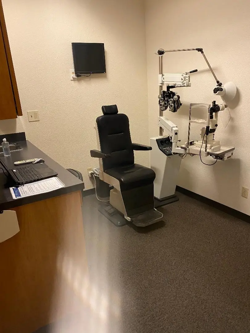 Exam room with medical equipment and chairs at Walzem EyeTX.