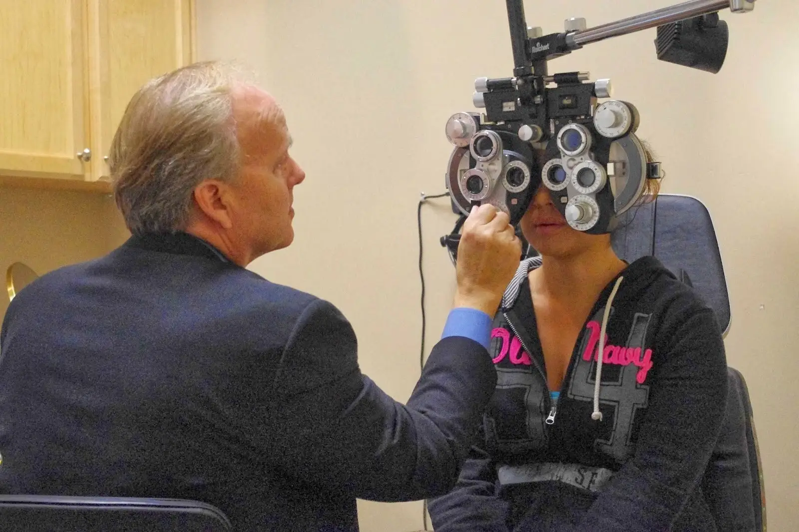 Picture of Doctor Woolf performing an eye exam.