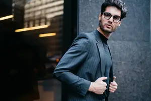 Man in a suit giving a thumbs up next to a building