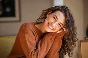 woman smiling and wearing a sweater
