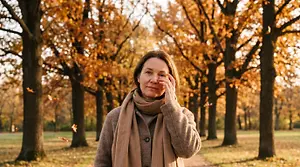 Woman touching her eye in an autumn forest