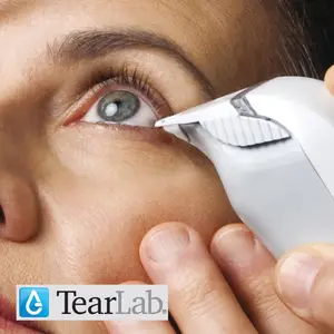 A woman using a TearLab device on her eye.