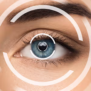 A close-up of a woman's eye with a white circle and a reflection of a person in the center