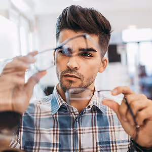 A man trying on glasses in a store