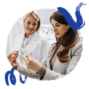 Two women, one wearing a lab coat, are examining a pair of glasses.