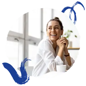 A smiling woman in a white shirt sitting in a chair in an office