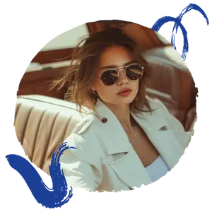 A woman wearing sunglasses, a white jacket, and a necklace sits in a car.