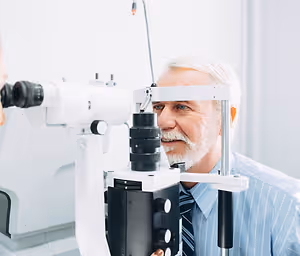 An elderly man has his eyes examined