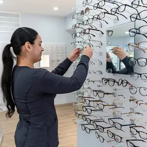 A woman is looking at a wall of glasses
