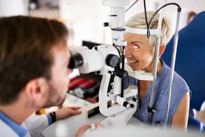 Doctor examining elderly woman's eye with a magnifying tool