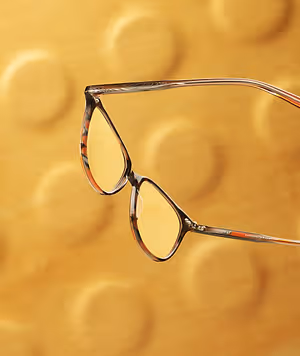 Close-up of a pair of eyeglasses with a yellow background in Stockbridge