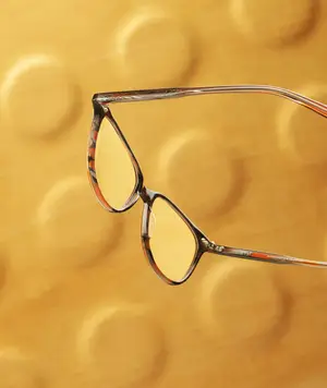 Close-up of a pair of eyeglasses with a yellow background in Stockbridge