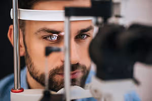 a man using a machine to check his eyes in a clinic