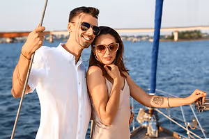 Man holding a rope while woman touching her face with a tattoo on her right arm