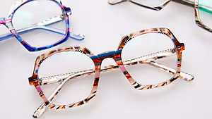 three pairs of glasses with colorful frames on a white surface