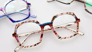 three pairs of glasses with colorful frames on a white surface