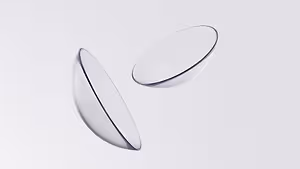 Two clear plastic contact lenses on a white background.