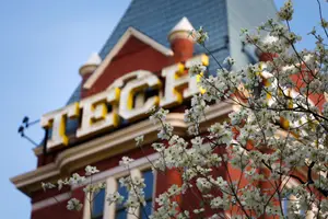 A building with white flowers in front of it, with the word 'TECH' on it