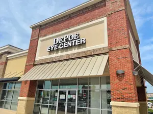 A brick building with glass doors and windows and an awning with the words Depo Eye Center on it