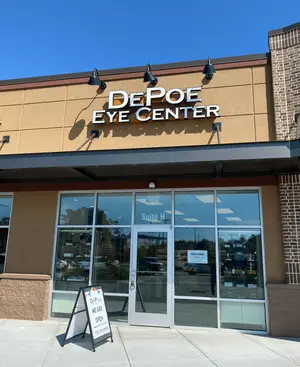 The front entrance of DePoe Eye Center is pictured with a sign indicating that they are open