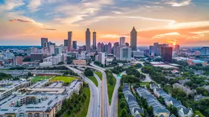 A breathtaking aerial view of a city skyline at sunset, with tall buildings and a highway stretching into the distance