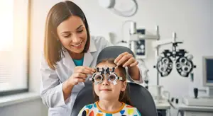 A woman doctor is checking a young girl's vision in an office.