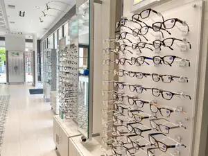 A shop displaying many glasses on the wall with white walls and tiled floors