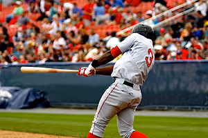 Baseball player number 3 swings the bat in an outdoor stadium with a crowd watching in the background