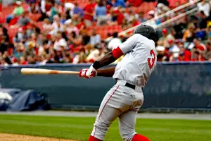 Baseball player number 3 swings the bat in an outdoor stadium with a crowd watching in the background