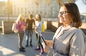 Woman holding a tablet with a smiling face on a city street