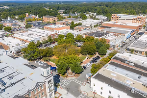An aerial view of a city with many buildings, cars, and trees.