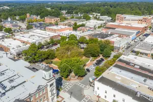 An aerial view of a city with many buildings, cars, and trees.
