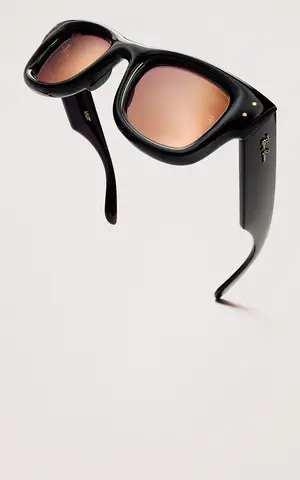 Black Ray-Ban sunglasses with brown lenses and gold accents on a white background