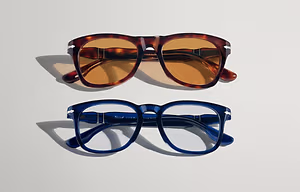 Two pairs of glasses on a white background, one brown and one blue