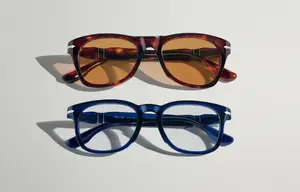 Two pairs of glasses on a white background, one brown and one blue