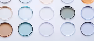Multiple round objects in various colors and shades, including white, gray, blue, and gold, displayed on a white surface