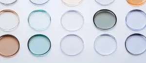 Multiple round objects in various colors and shades, including white, gray, blue, and gold, displayed on a white surface