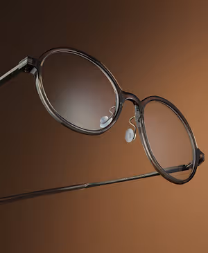 A pair of round-shaped glasses with black frames and gray lenses