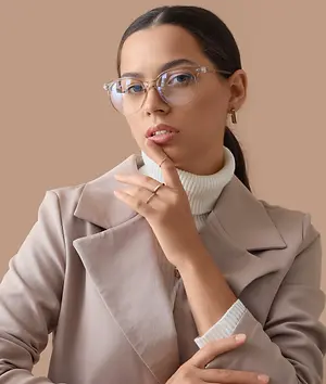 Woman wearing clear eyeglasses and a beige blazer
