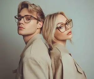 Young man and woman wearing stylish eyeglasses and standing back to back