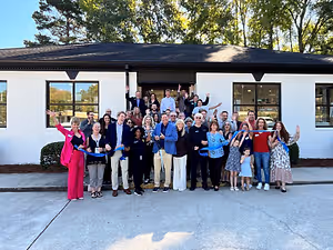 Large group posing outside an optometry practice building