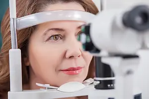 A woman is having her eyes examined by a doctor in a clinic.