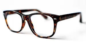 Black tortoise-shell-patterned glasses with clear lenses and silver-colored metal tips on a white background
