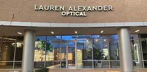Lauren Alexander Optical, a store with a glass door and windows, has a plant inside.