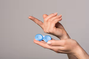 A person holding a blue lens in their hand