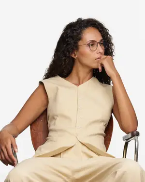 A woman sitting on a chair with her hand on her chin and looking to the left