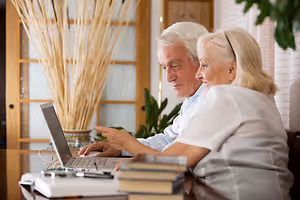 Senior couple working on laptop at home