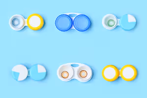 Six colored contact lenses in containers against a blue background