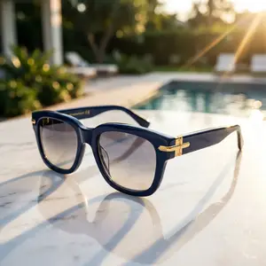 Blue glasses with gold details rest on a marble surface near a pool.